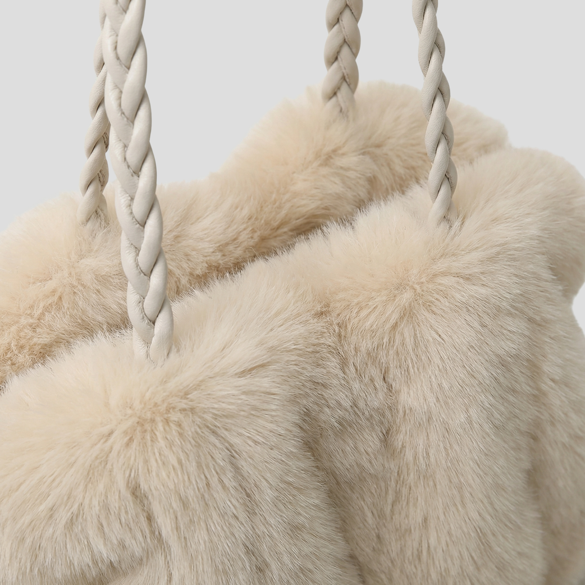 Oversized tote bag with braided handle detail, shown in black, brown, and beige