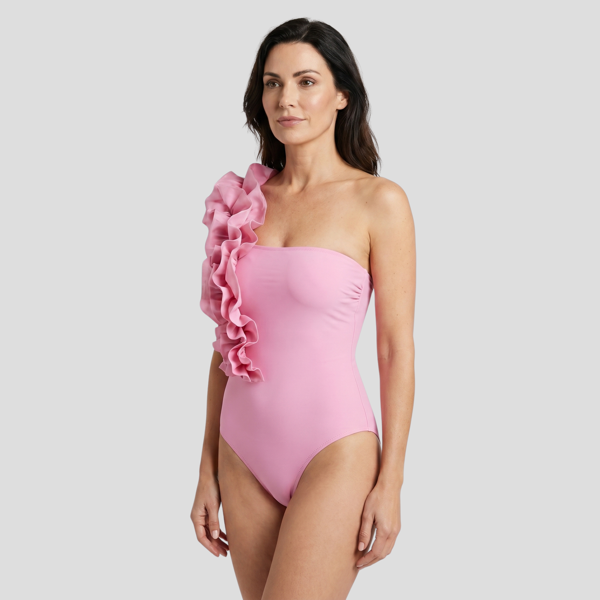 Pink one-piece swimsuit with asymmetrical neckline and ruffle-detail strap