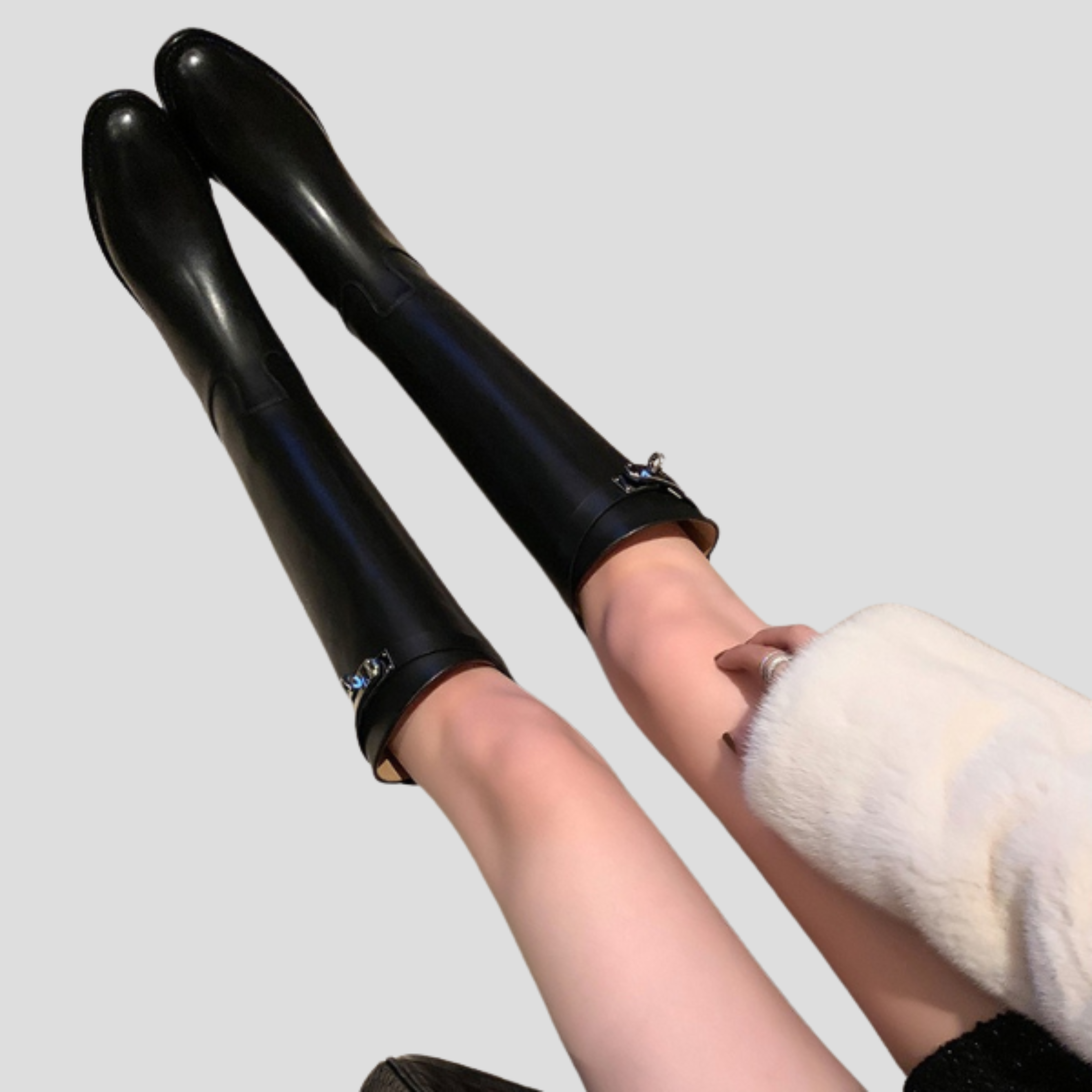 Black knee-high boots with buckle detail on the shaft and a rounded toe