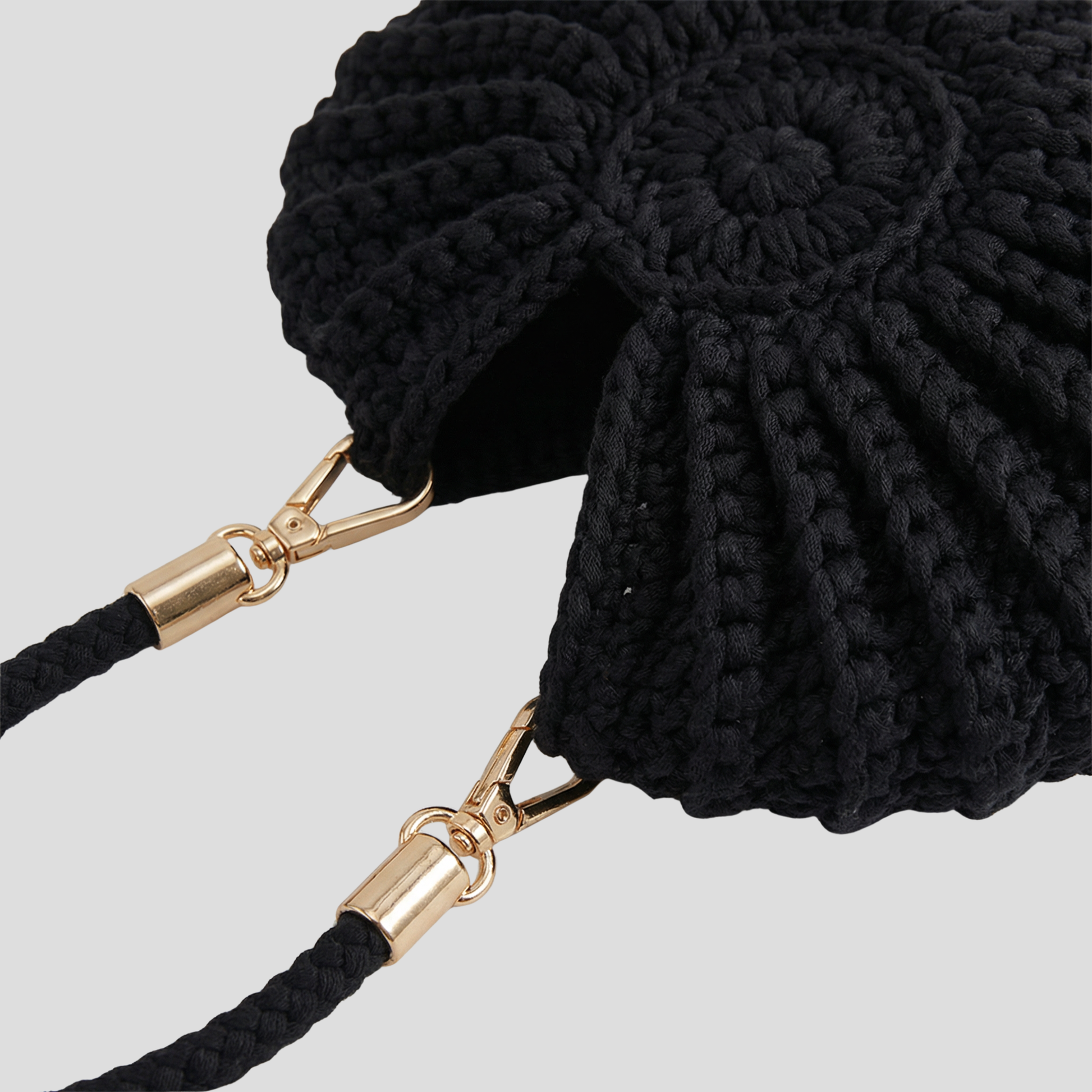 Conch-shaped woven handbag with sculptural silhouette, shown in blue, black, and white