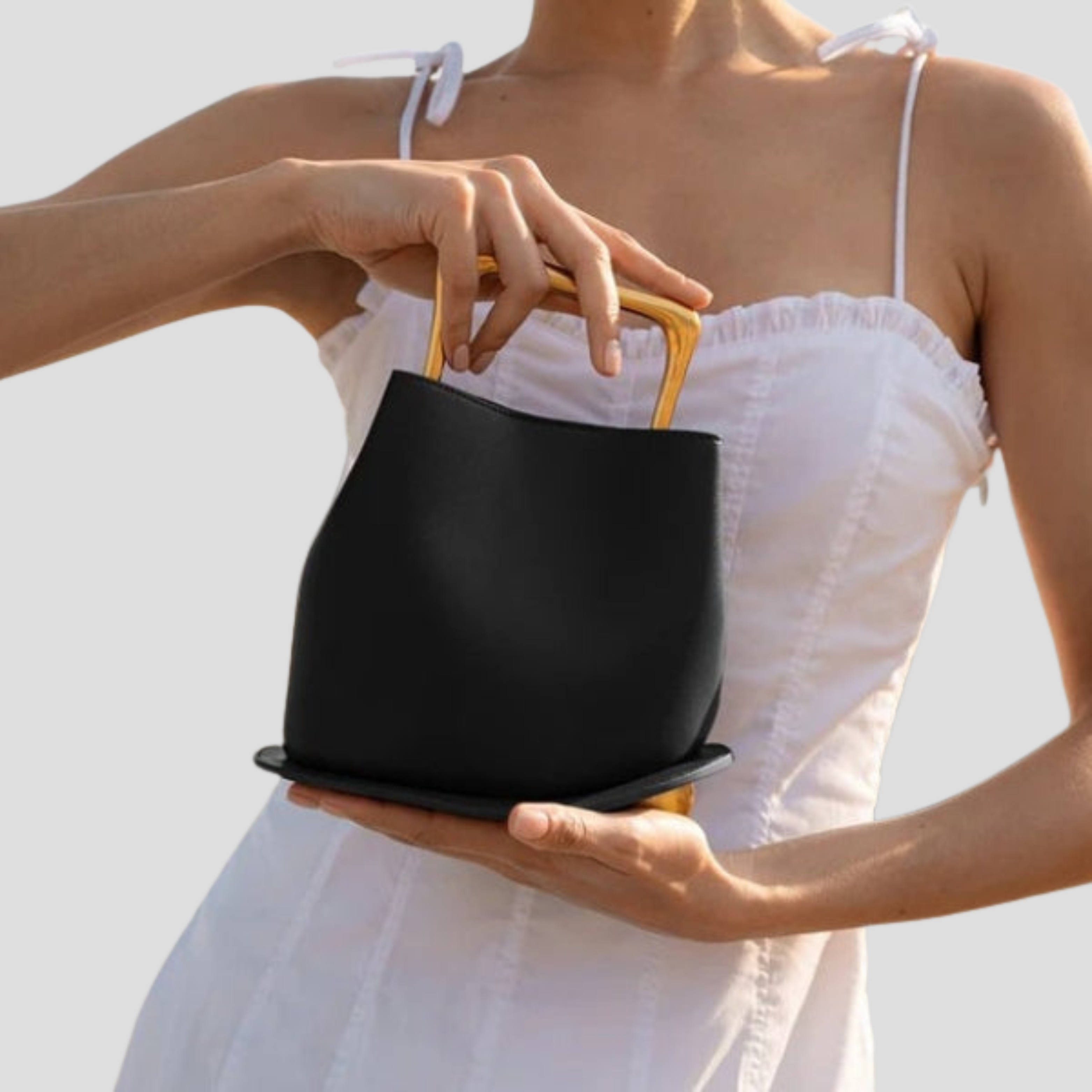 Rounded mini handbag with sculpted handle shown in neutral colorways
