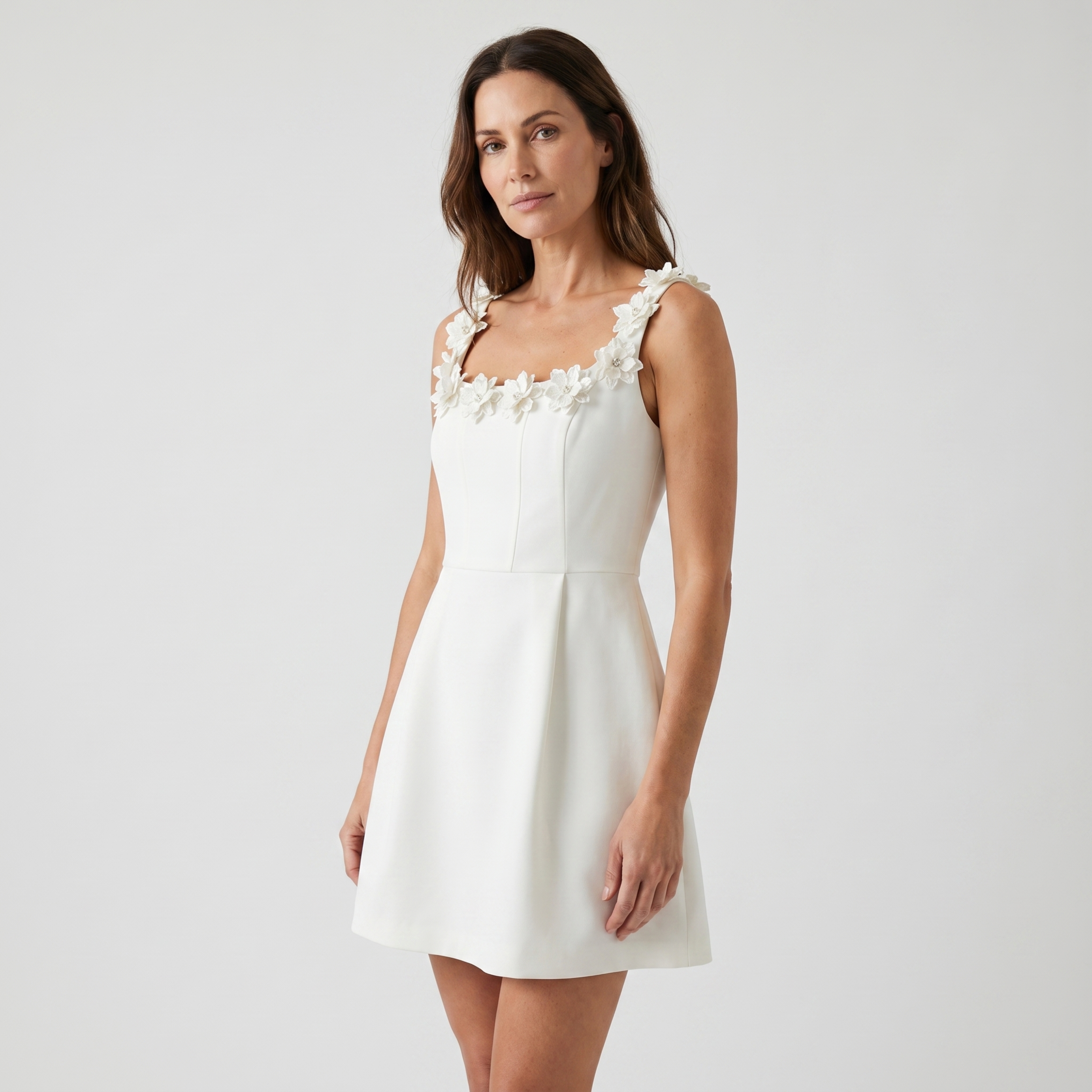 White mini dress with square neckline and floral shoulder strap details
