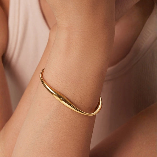Gold open cuff bracelet with sculpted asymmetrical curve and rounded edges