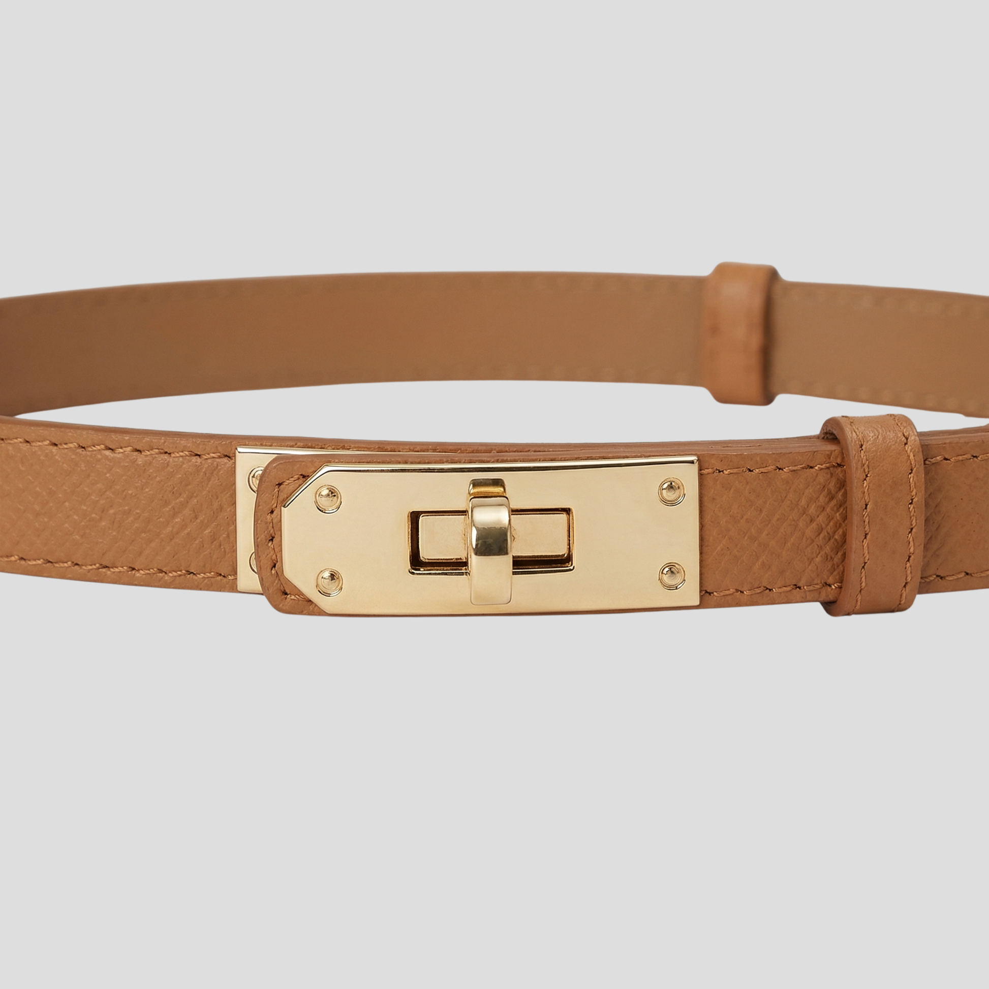 Women's straight-strap belt with a defined buckle, shown in neutral colors