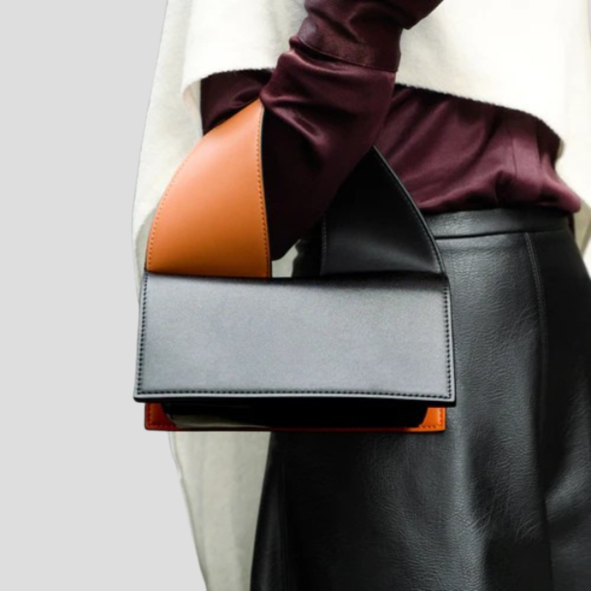 Black structured women's handbag with two-tone handle detail for daily wear