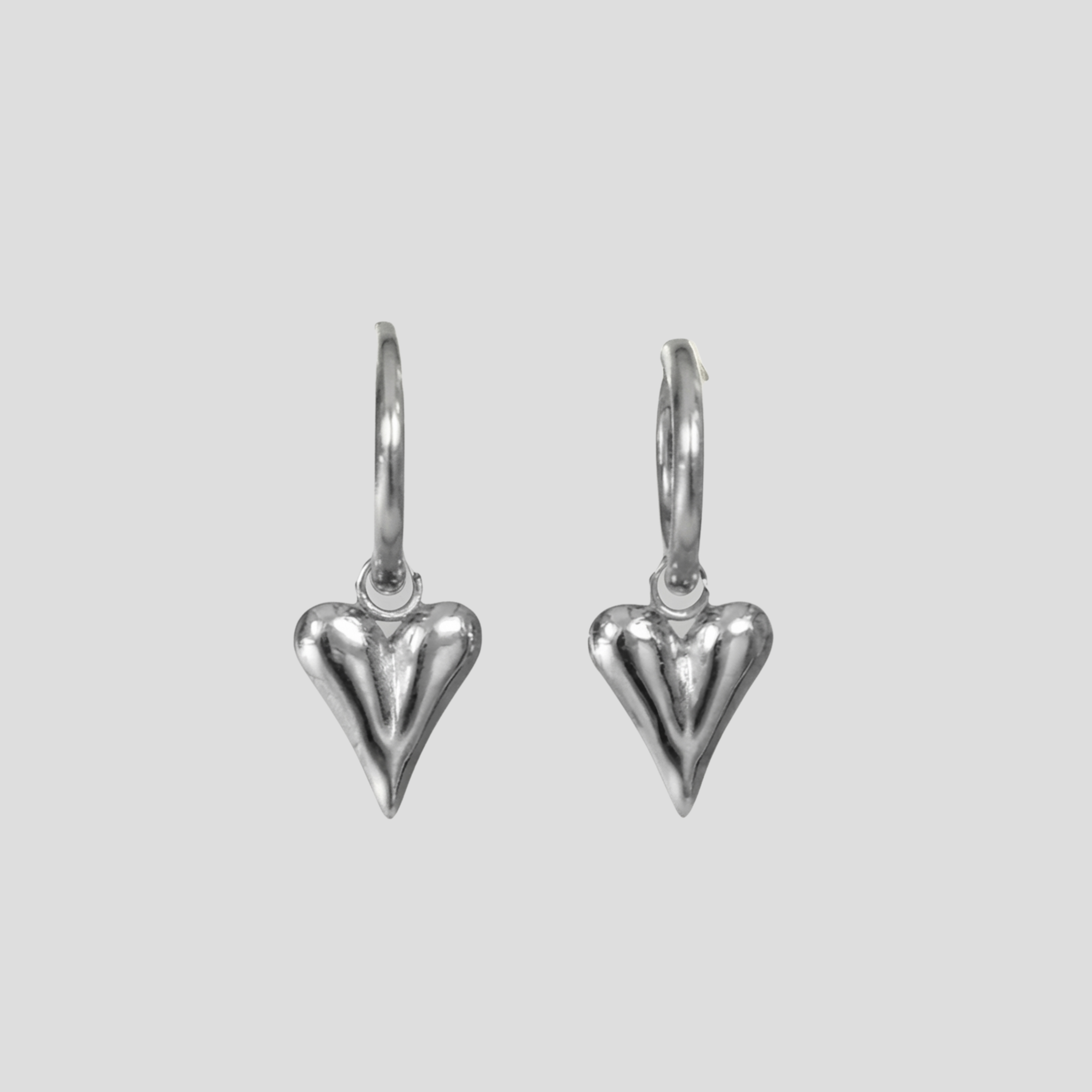 Sculpted heart-shaped earrings with a polished silver finish for women