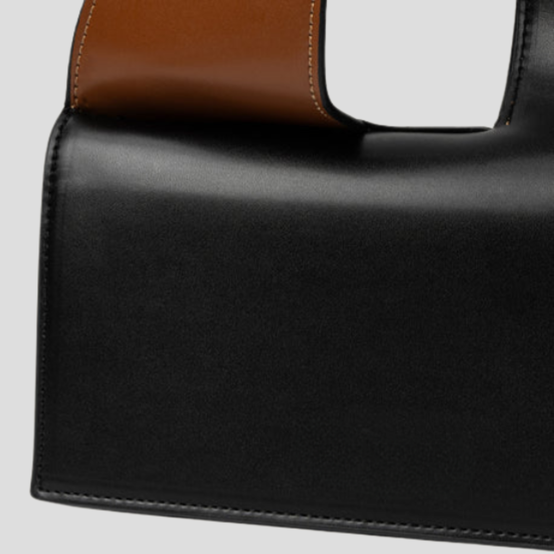Black structured women's handbag with two-tone handle detail for daily wear
