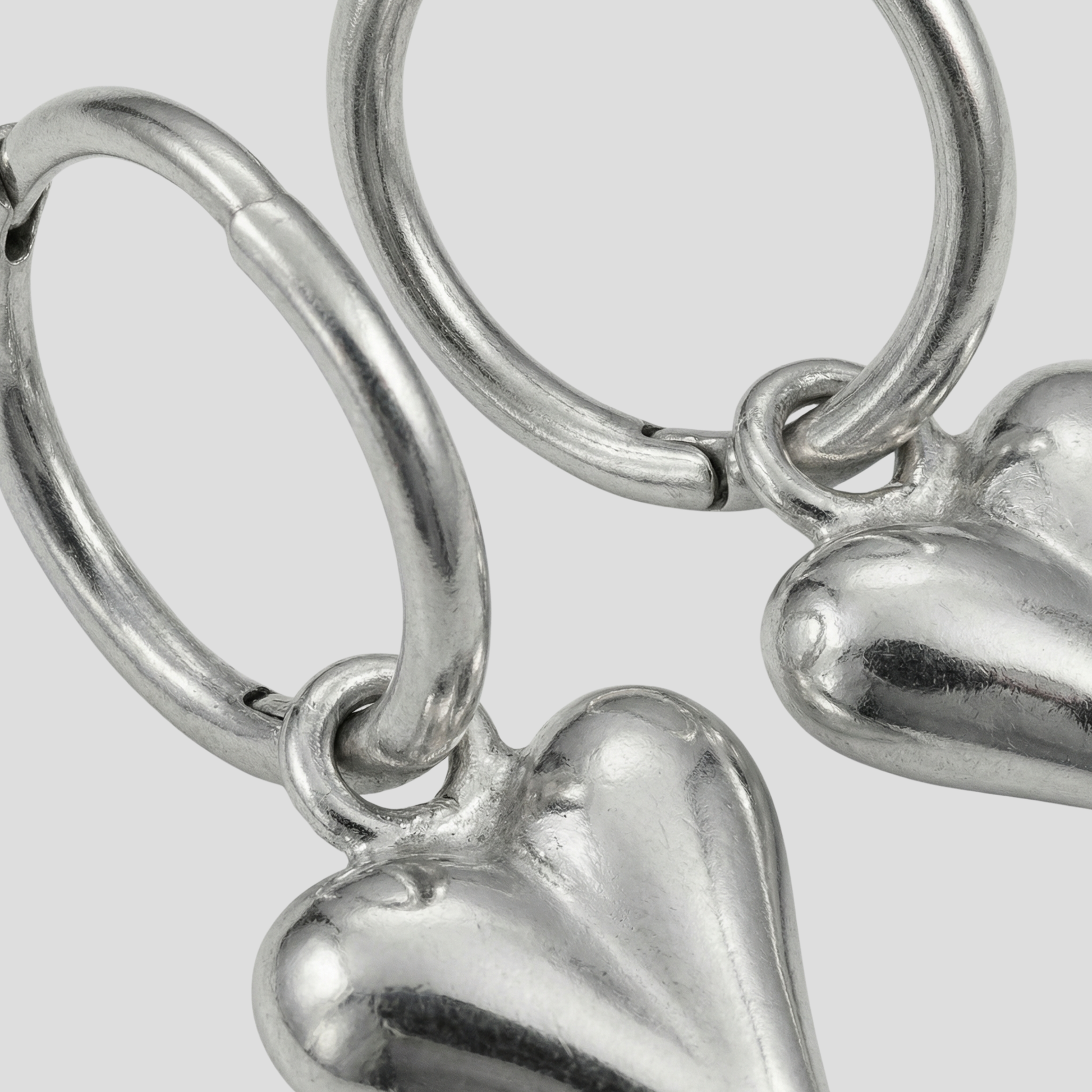 Sculpted heart-shaped earrings with a polished silver finish for women