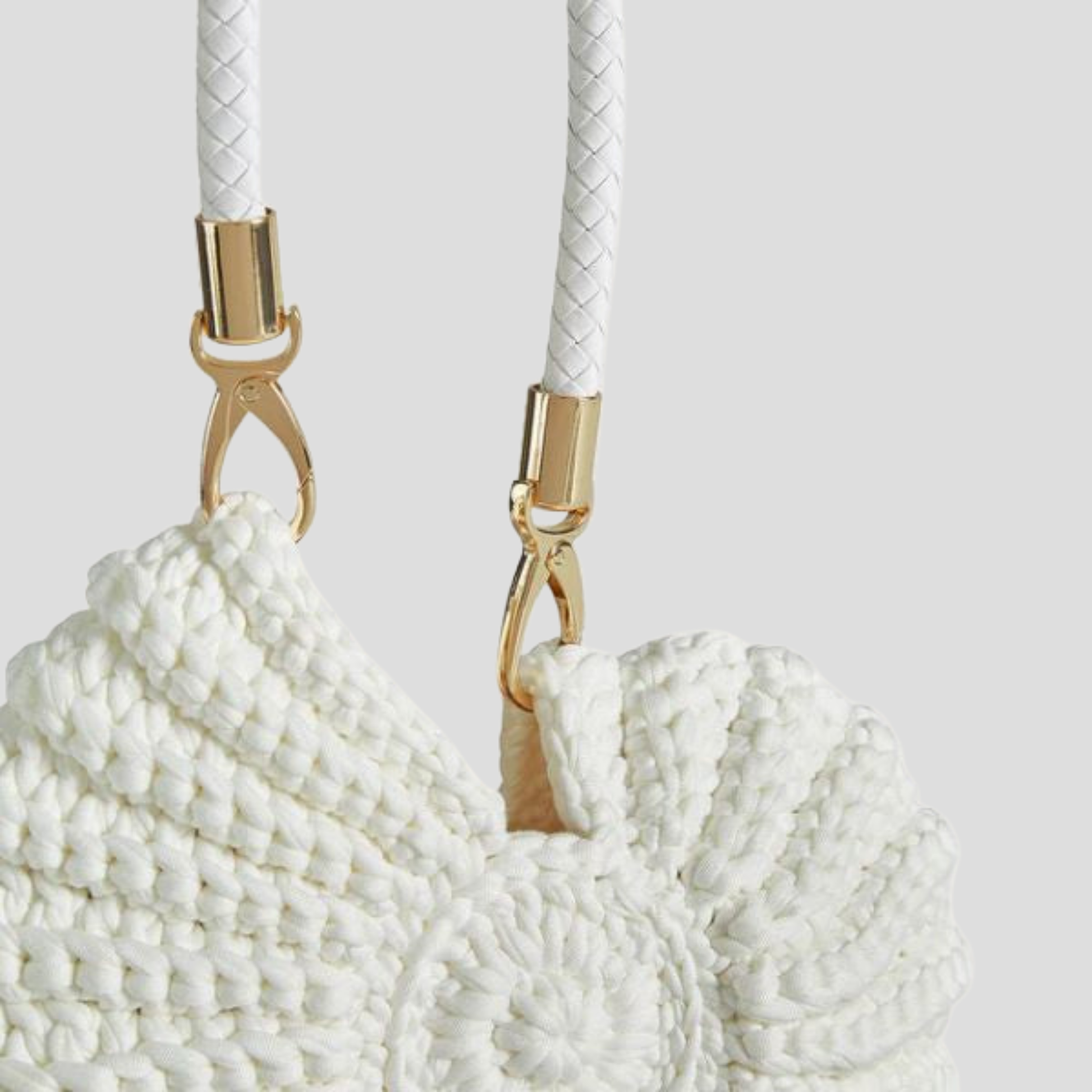 Conch-shaped woven handbag with sculptural silhouette, shown in blue, black, and white