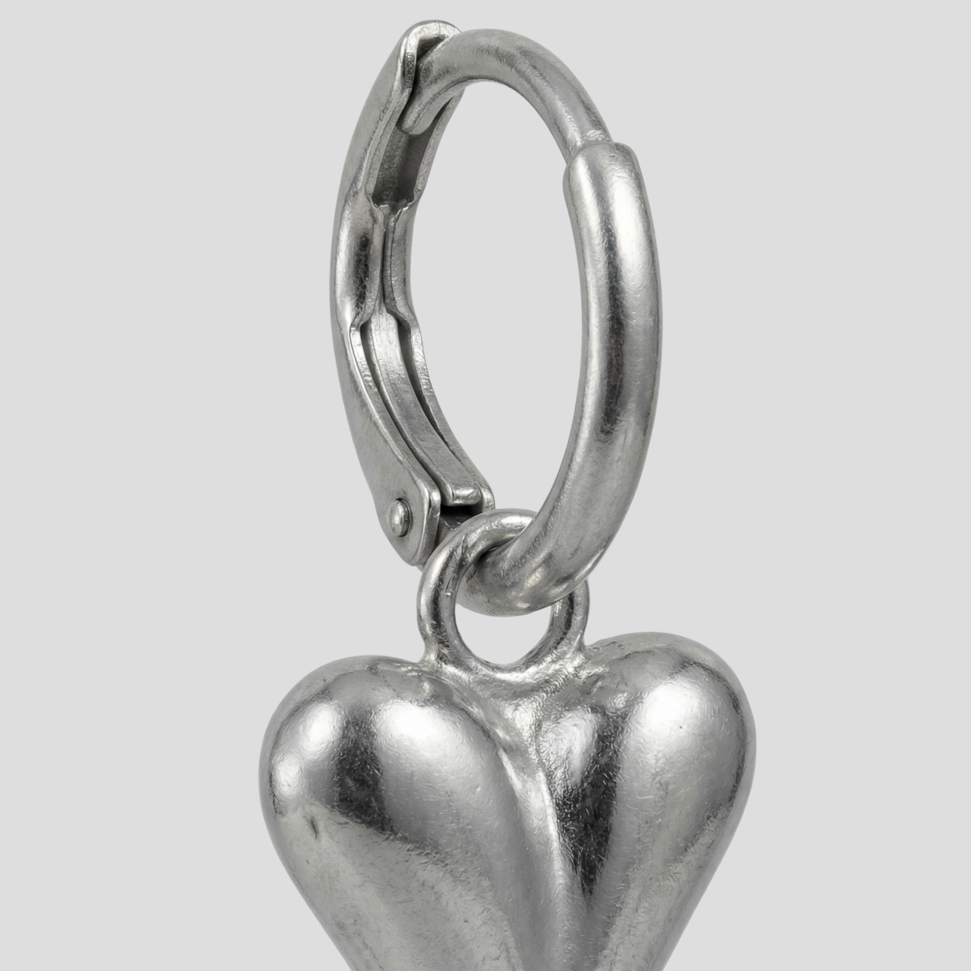 Sculpted heart-shaped earrings with a polished silver finish for women