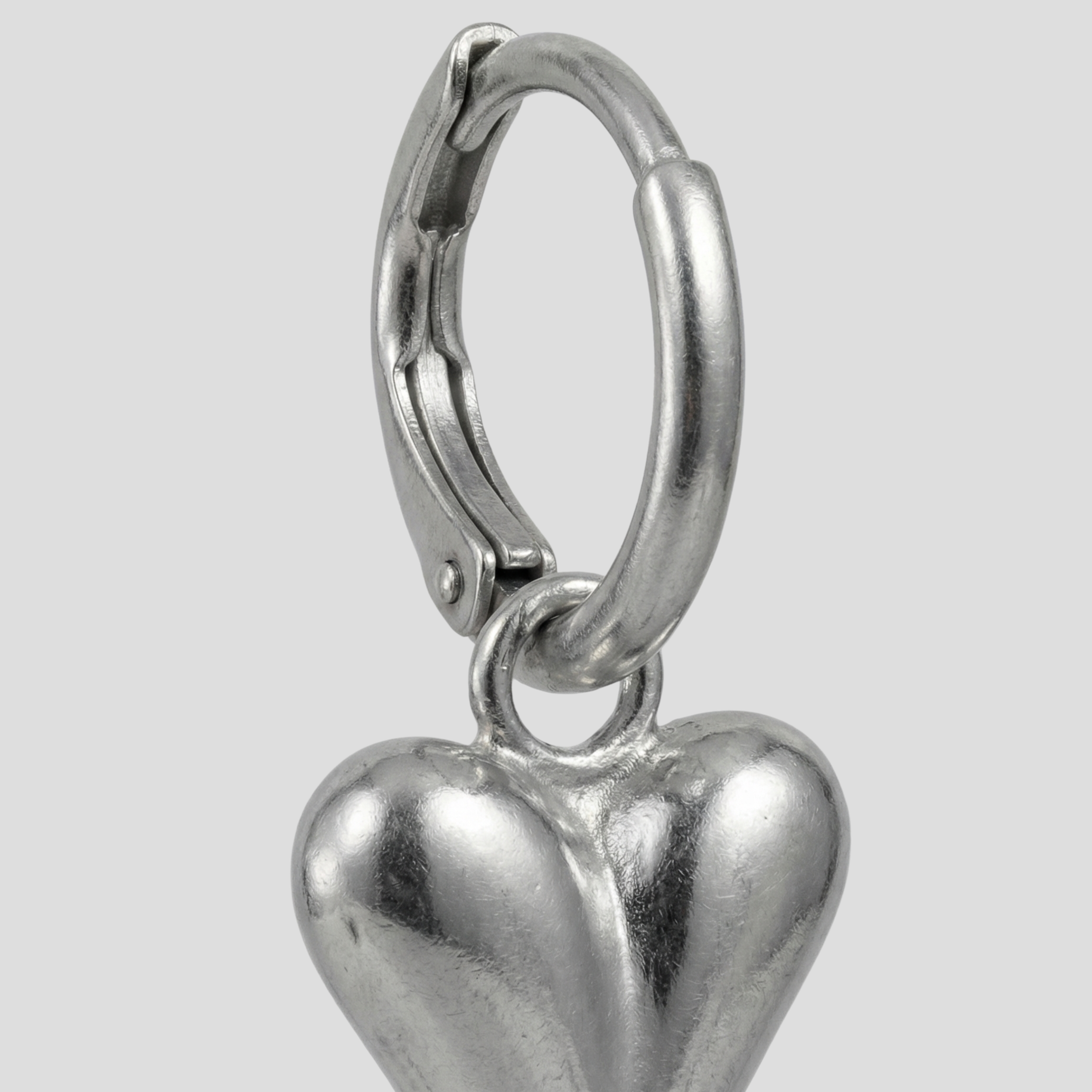 Sculpted heart-shaped earrings with a polished silver finish for women