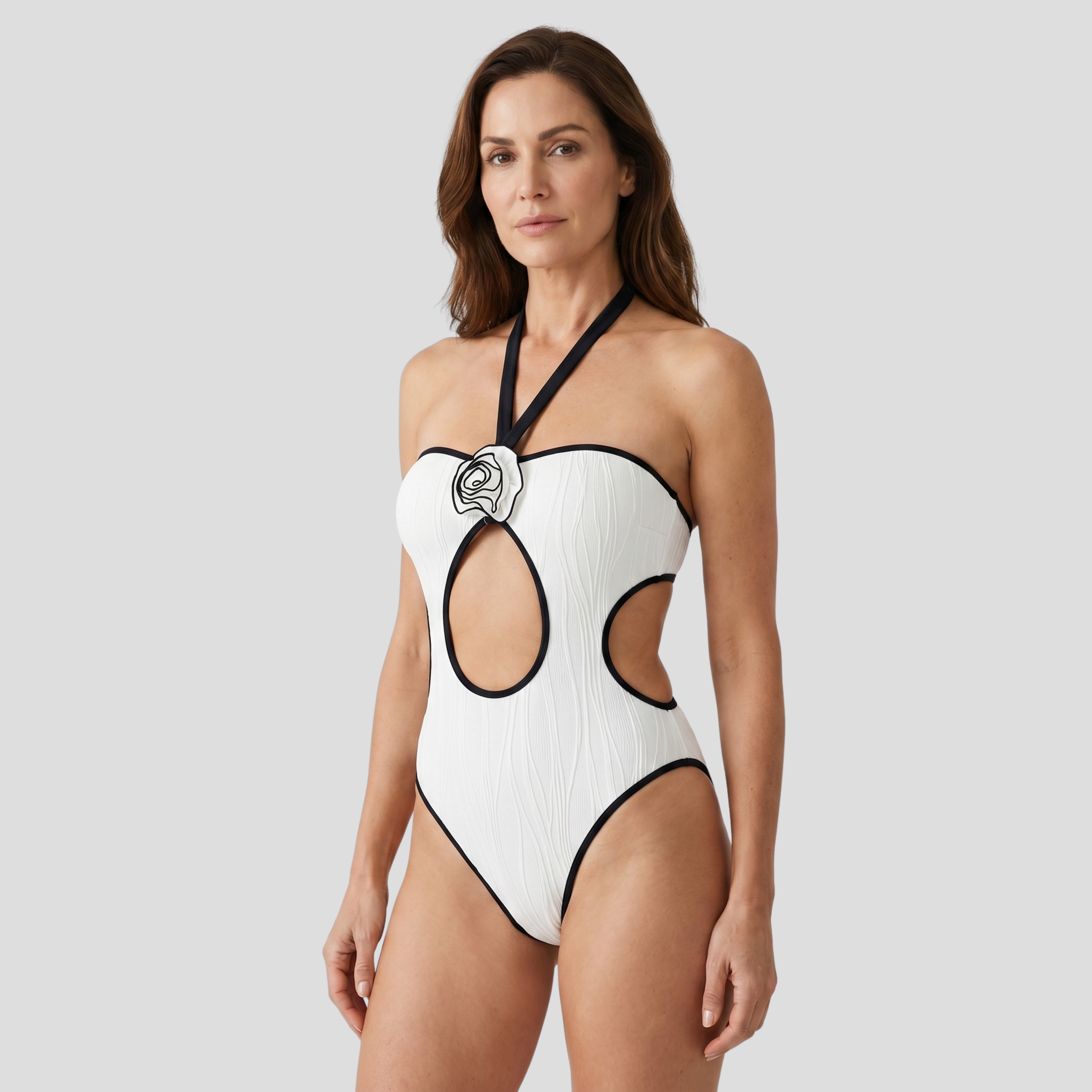 White one-piece swimsuit with halter neck, central rose appliqué and front cutout detail